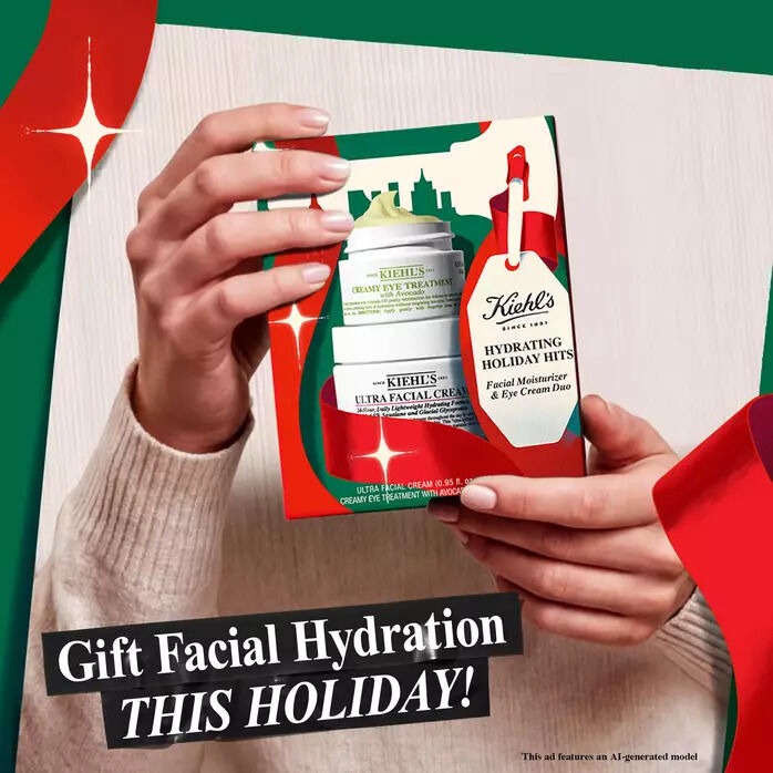 A pair of hands holds a Kiehl’s "Hydrating Holiday Hits" gift box containing Ultra Facial Cream and Creamy Eye Treatment with Avocado, decorated with festive red and green holiday elements.​