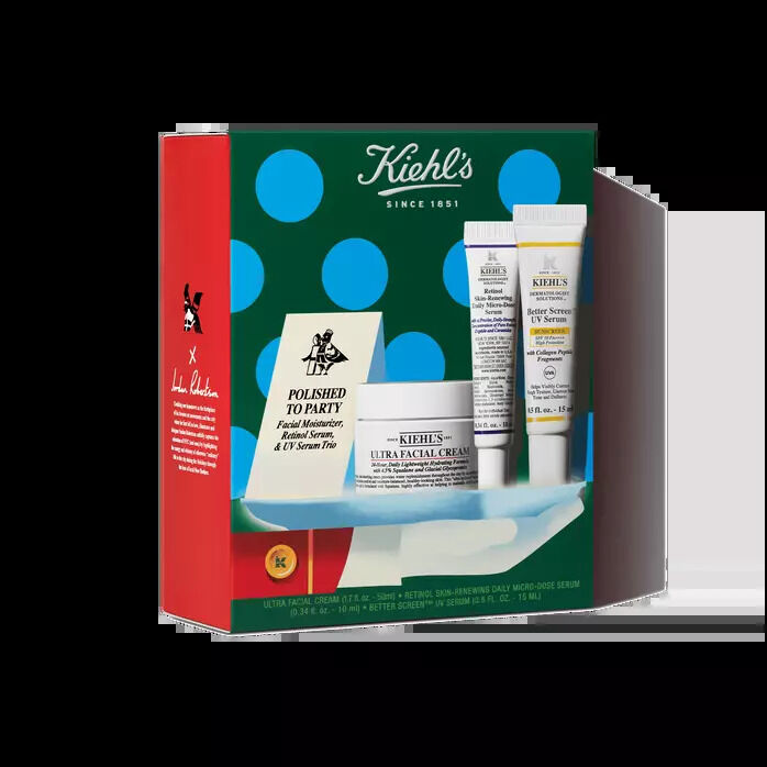 Kiehl's holiday skincare gift set featuring a moisturizer jar, two tubes, and a cartoned product inside festive green, red, and blue polka-dot packaging.​