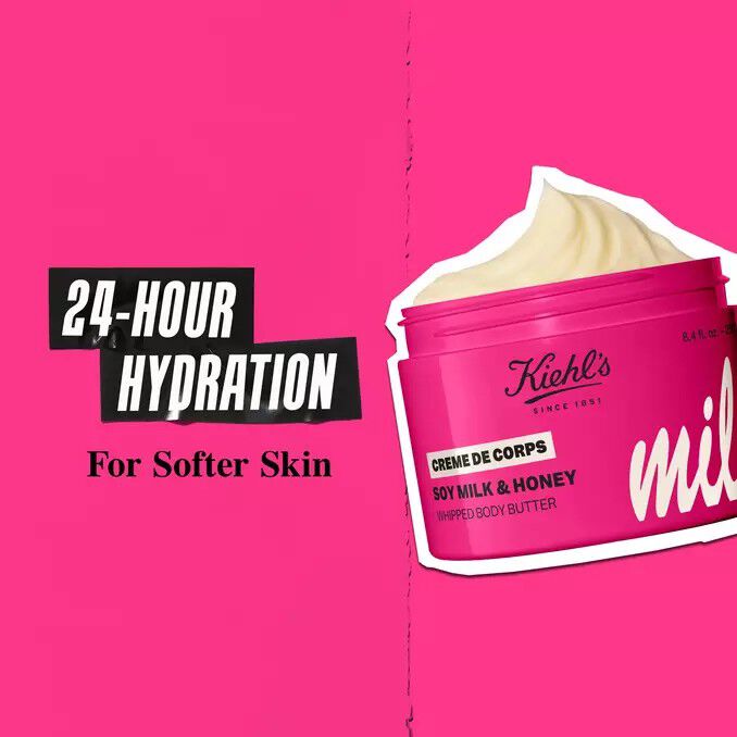 Kiehl’s Milk Bar Creme de Corps Whipped Body Butter in bright pink limited-edition packaging, with cream swirl and promotional text highlighting 24-hour robust hydration for softer skin.​