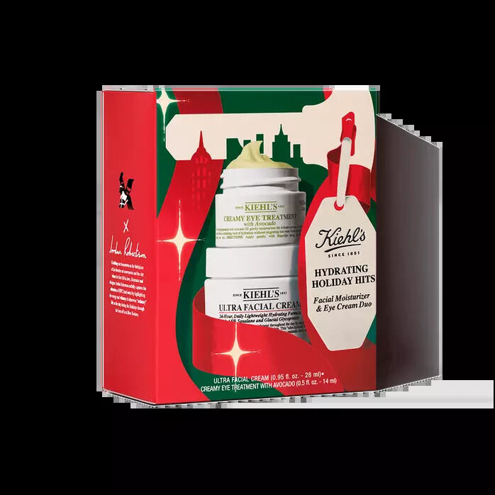 Kiehl's "Hydrating Holiday Hits" skincare gift set box featuring Ultra Facial Cream and Creamy Eye Treatment with Avocado, decorated in red and green with holiday festive graphics.​