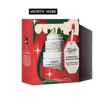 Hydrating Holiday Hits" skincare gift set on a green background, featuring Ultra Facial Cream and Creamy Eye Treatment with Avocado in festive packaging.​