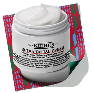 Open jar of Kiehl's Ultra Facial Cream set against a holiday-themed patterned background.​