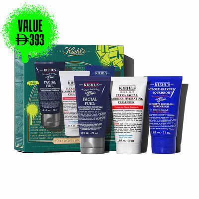 A graphic, set against a dark green textured background, features three Kiehl’s products. A white tube of "KIEHL’S ULTRA FACIAL BARRIER-HYDRATING CLEANSER" is labeled "TRAVEL SIZE" in bright green. A blue tube of "KIEHL’S 'CLOSE-SHAVERS' SQUADRON ULTIMATE BRUSHLESS SHAVE CREAM" is also labeled "TRAVEL SIZE" in bright green. A dark blue tube of "KIEHL’S FACIAL FUEL MOISTURIZER" is labeled "TRAVEL SIZE" in bright green. In the lower right, a partially visible green Kiehl’s gift box showcases the same three products.